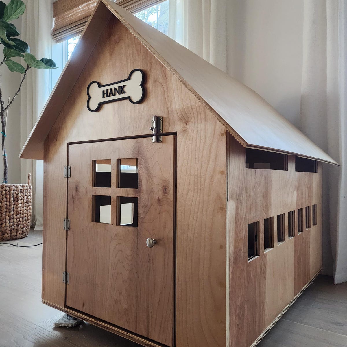 Personalised Dog's Name Wall Sign Shaped as a Bone, with Raised Wooden Wording in Black against wooden background, Pet Gift