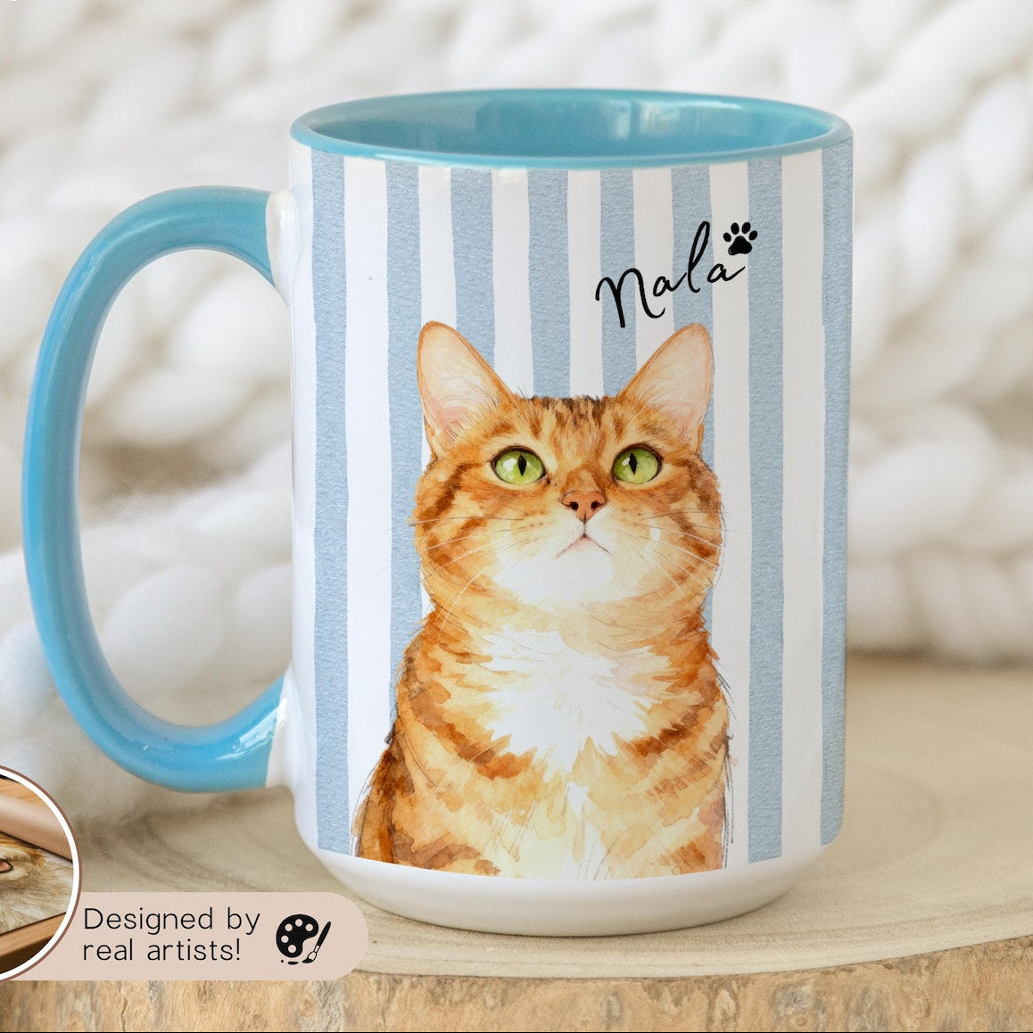 Mug with a cat design and blue interior on a wooden surface

