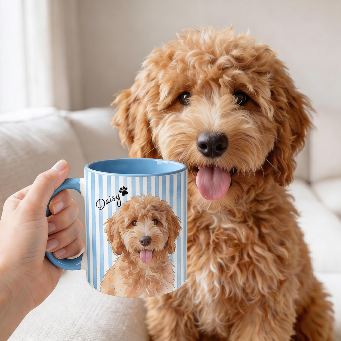 Dog sitting next to a person holding a mug with a dog illustration on a couch.

