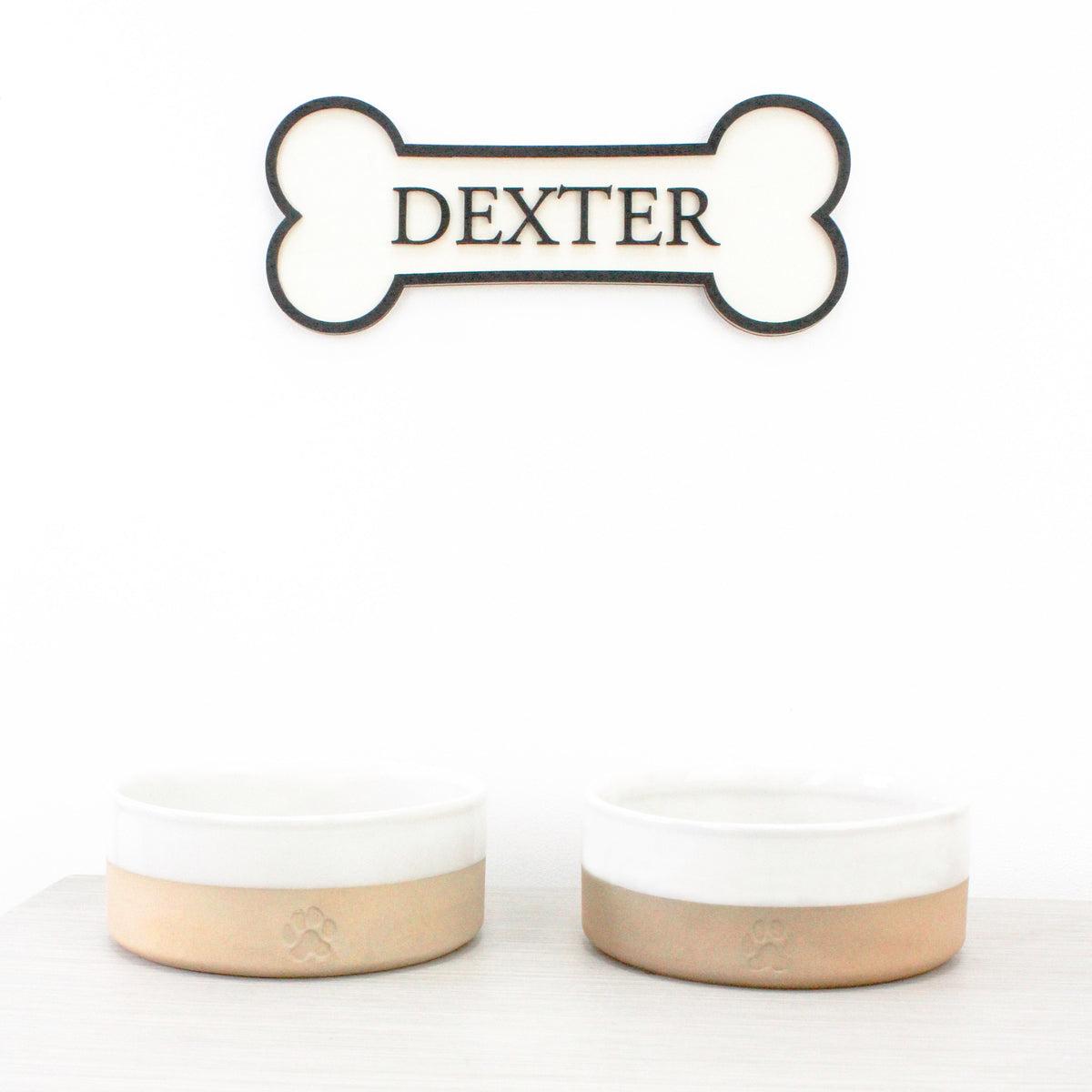 Personalised Dog's Name Wall Sign Shaped as a Bone, with Raised Wooden Wording in Black against wooden background, Pet Gift